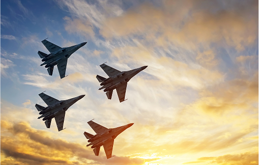 Hig-Quality_Mil-Spec_Wires3 Three fighter jets flying in tight formation above the clouds, armed with missiles and illuminated by soft sunlight.